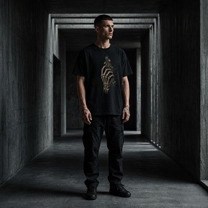 Man wearing a black t-shirt with a design in a dark, industrial hallway