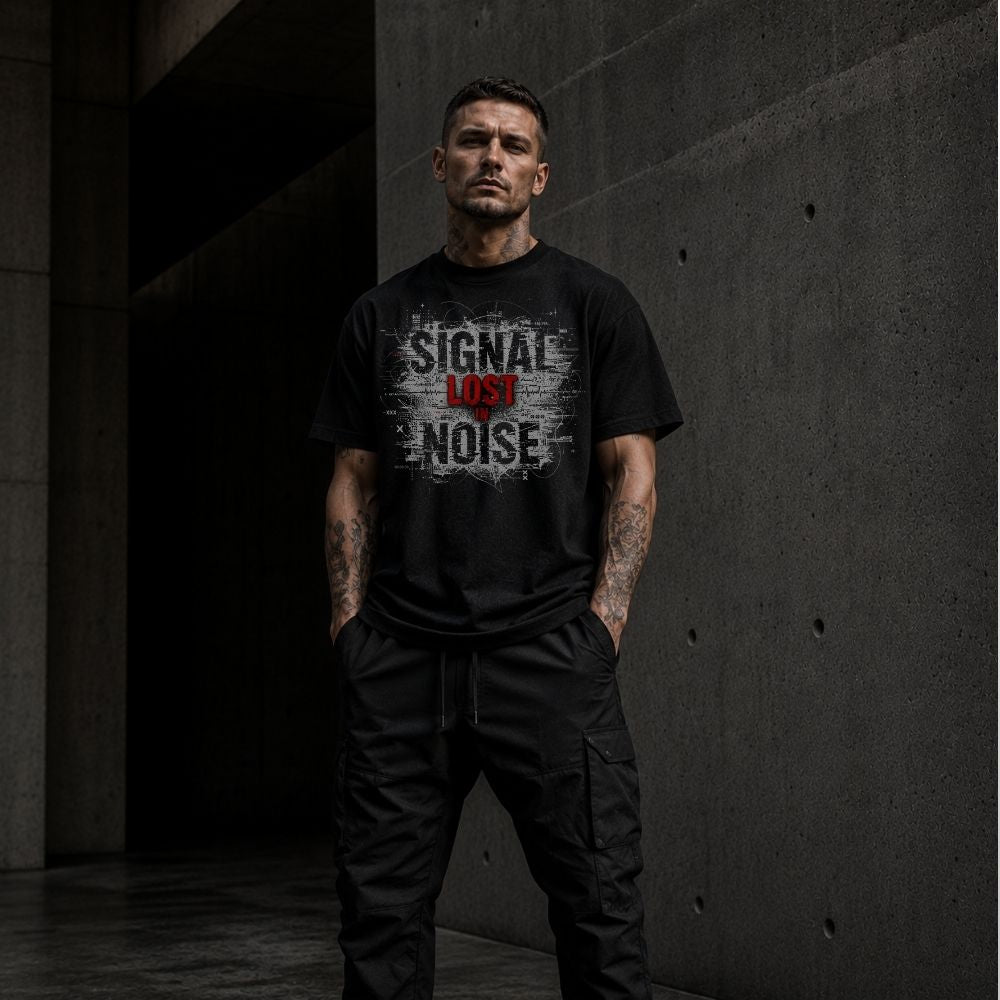Man wearing a black t-shirt with text standing in a dark, industrial setting