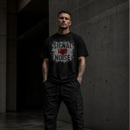 Man wearing a black t-shirt with text standing in a dark, industrial setting
