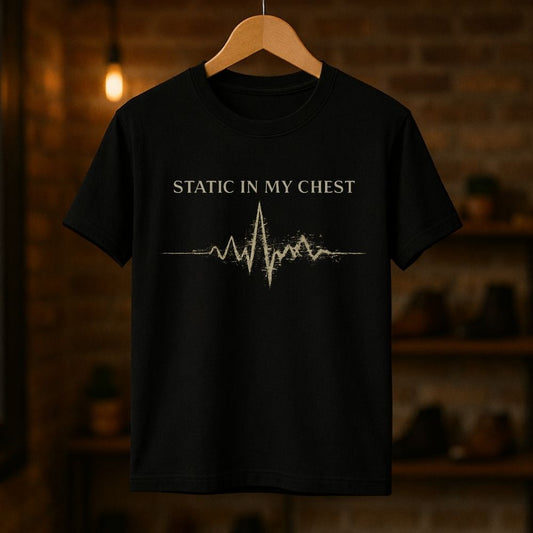 Black t-shirt with 'Static in My Chest' design on a wooden hanger against a dark background