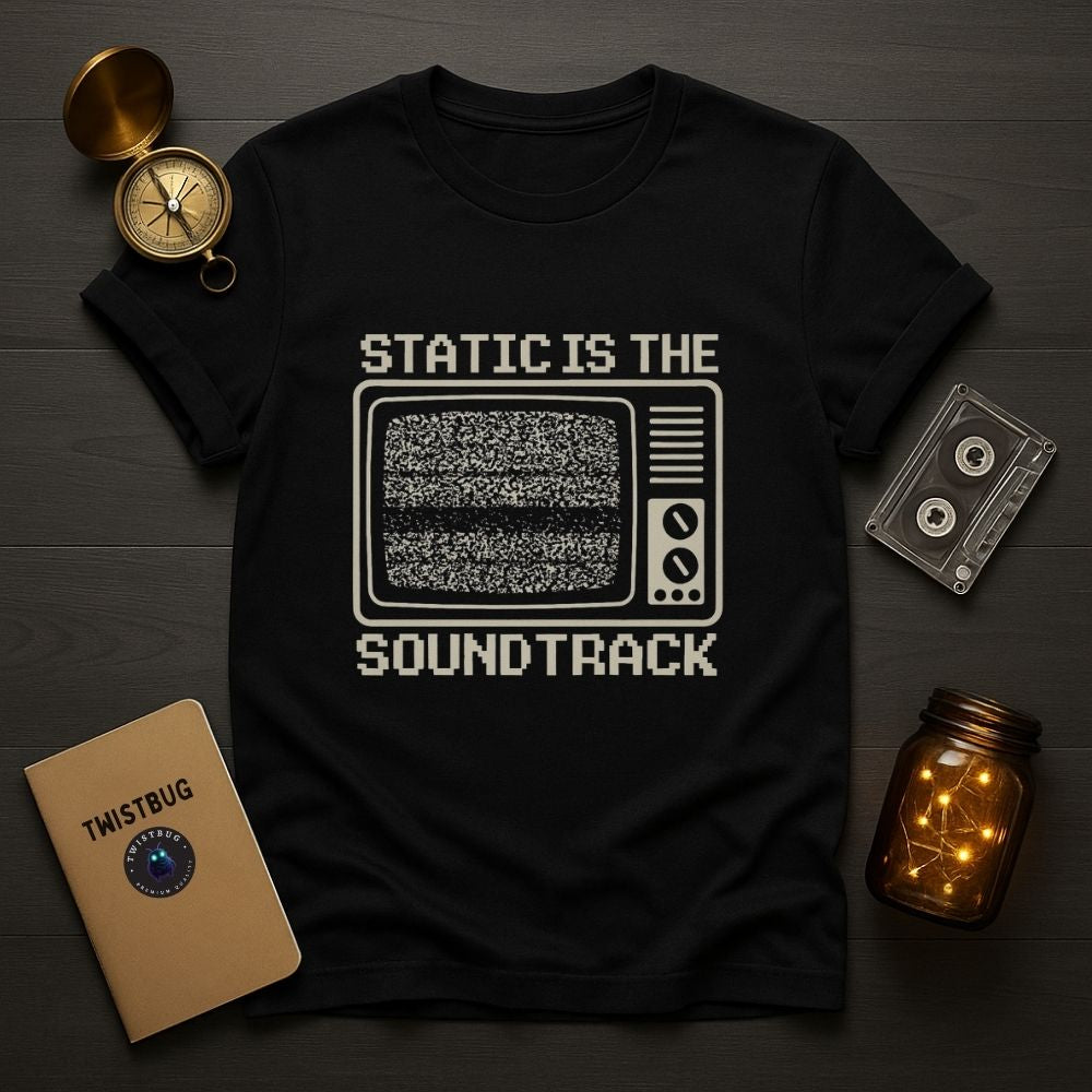 Black T-shirt flat lay with retro TV static graphic and analog props