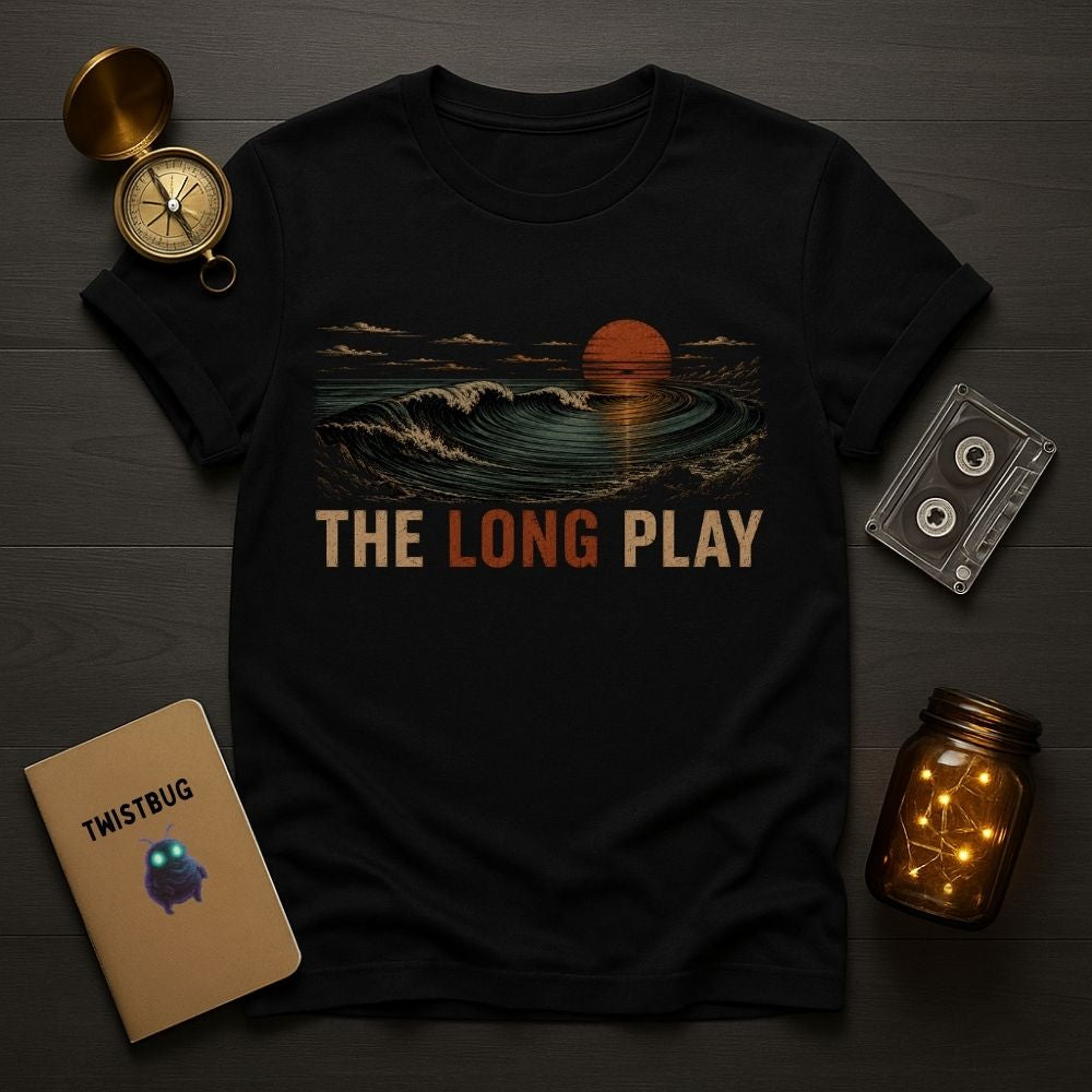 Black t-shirt with 'The Long Play' design on a wooden surface with decorative items.