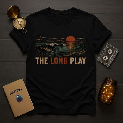 Black t-shirt with 'The Long Play' design on a wooden surface with decorative items.