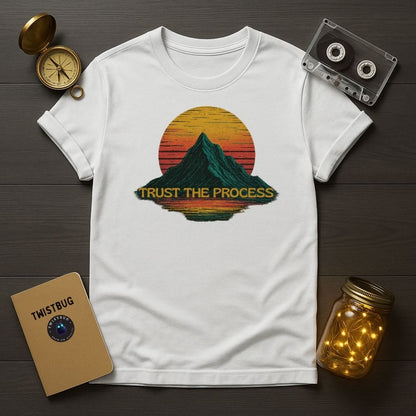 White “Trust the Process” mountain tee, minimalist flat lay setup.