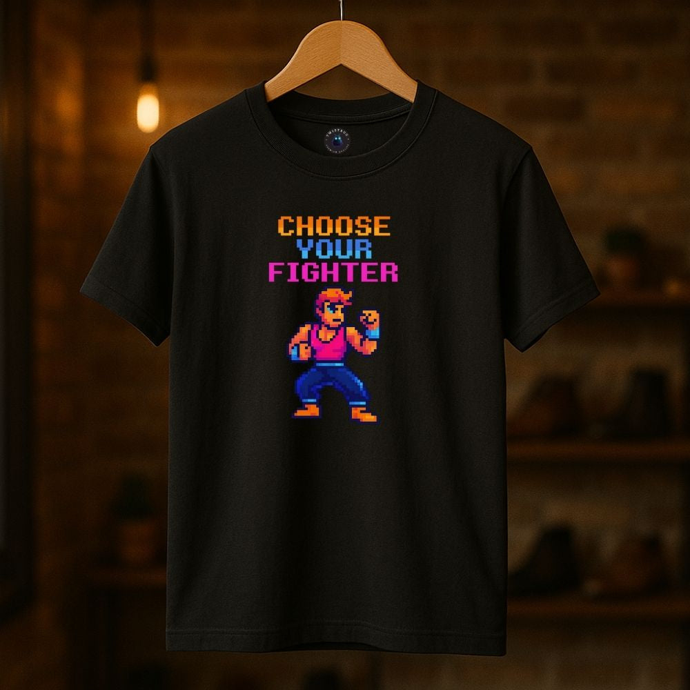 Black “Choose Your Fighter” T-shirt hanging in a warm-lit room, pixel art fighter design, retro gaming style.