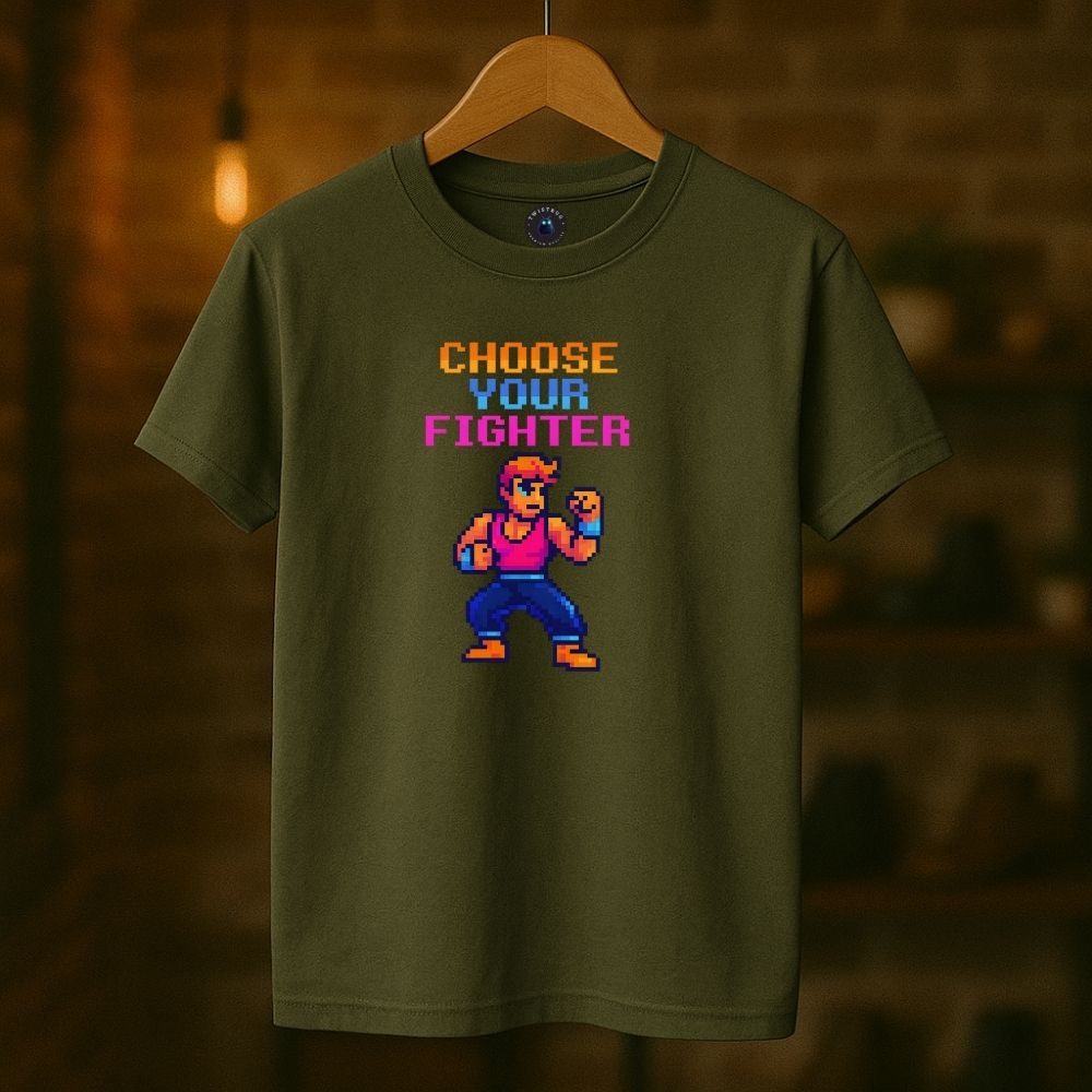 Military green “Choose Your Fighter” T-shirt hanging indoors, retro 8-bit arcade character design.
