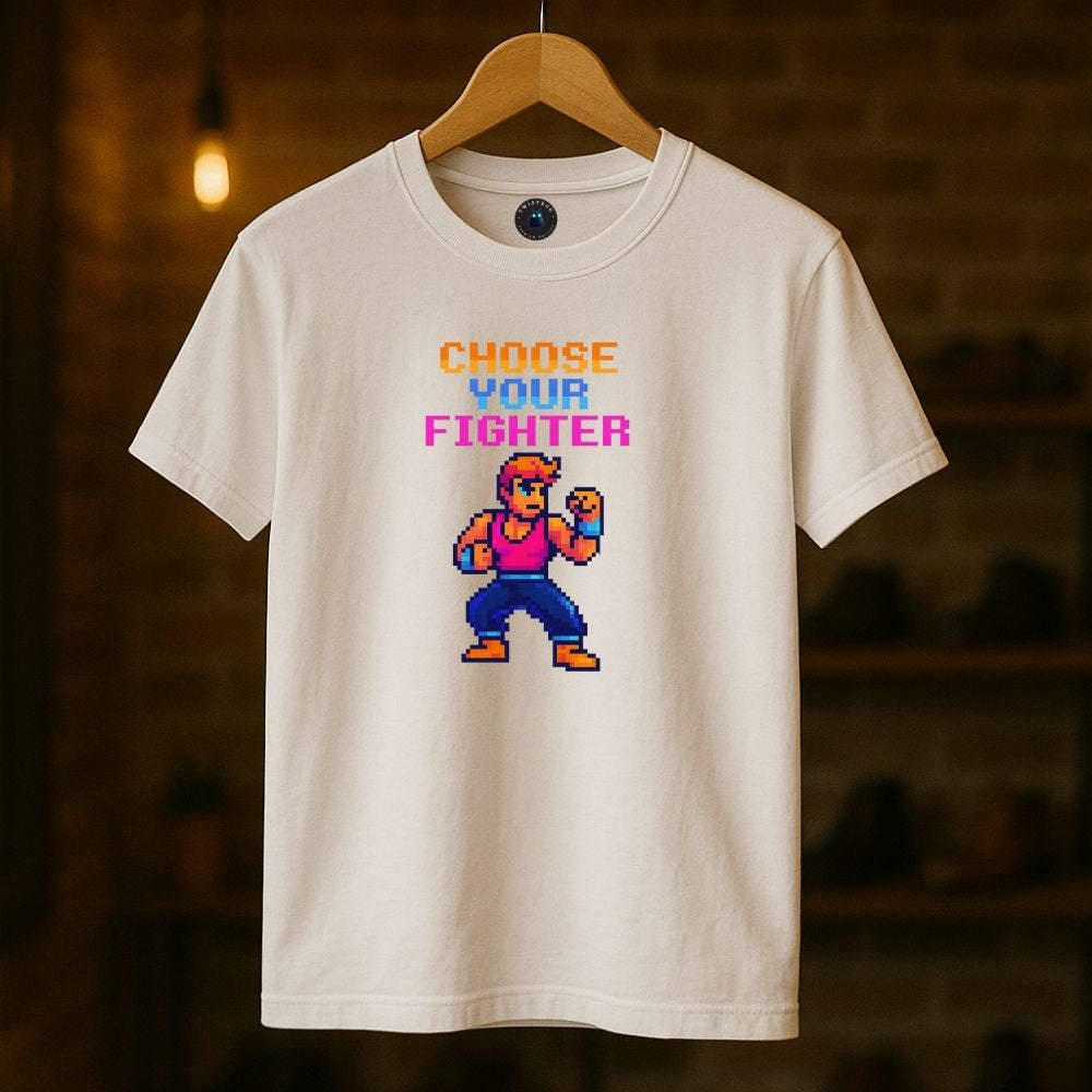 White “Choose Your Fighter” T-shirt hanging indoors with warm tone lighting, 8-bit fighter artwork.