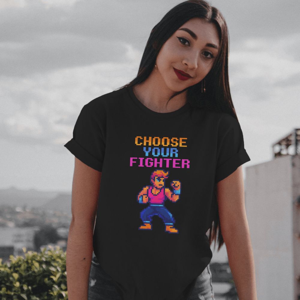 Woman wearing “Choose Your Fighter” T-shirt outdoors, urban style retro gamer aesthetic.