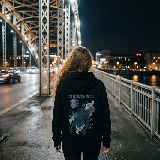 Woman wearing Dissociation Mode hoodie on a night city bridge, moody atmospheric streetwear photography