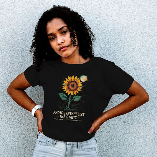 Woman wearing black Twistbug ‘Photosynthesize the Static’ sunflower T-shirt against a light textured wall.