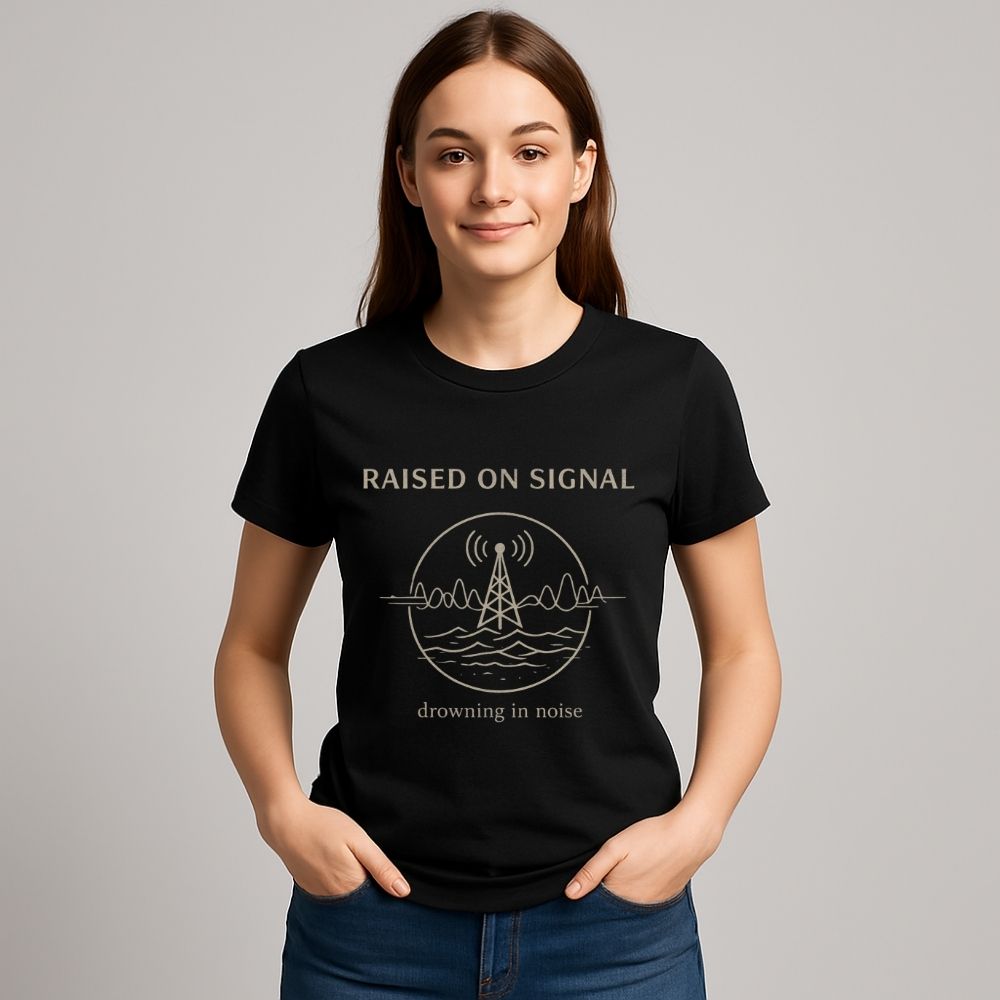 Person wearing a black t-shirt with 'Raised on Signal' design on a gray background