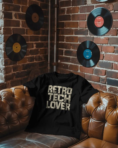 Black Twistbug t-shirt reading ‘Retro Tech Lover’ draped on a leather sofa in a retro lounge with brick wall and mounted vinyl records