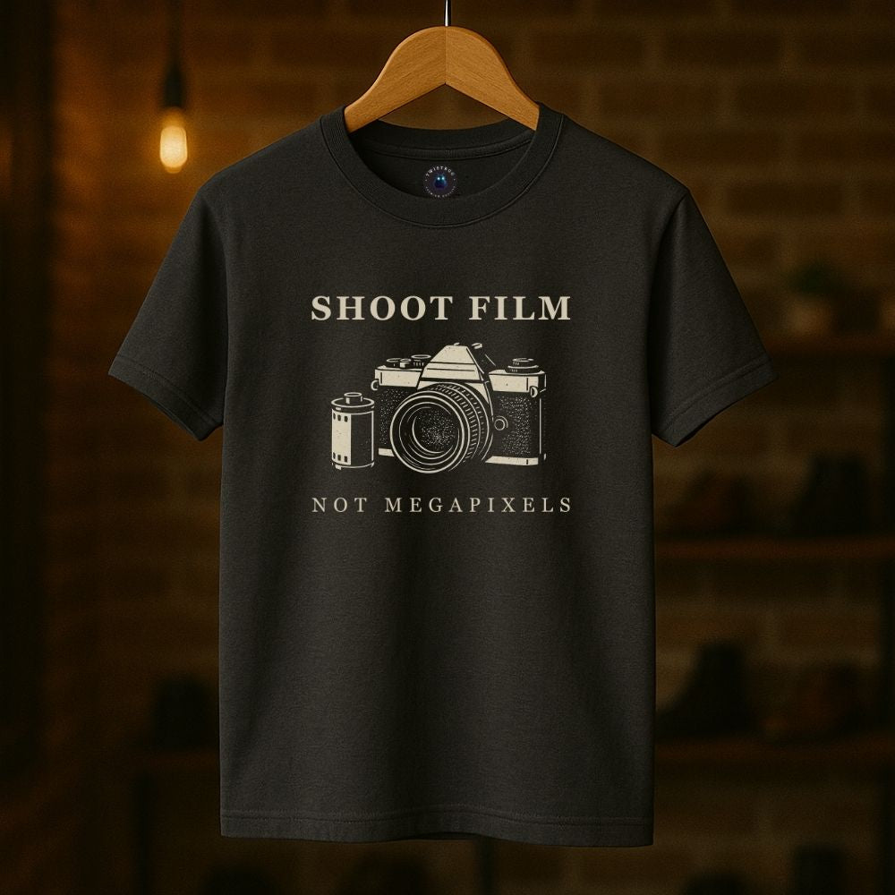 Charcoal Shoot Film Not Megapixels vintage camera t-shirt hanging on a wood hanger.