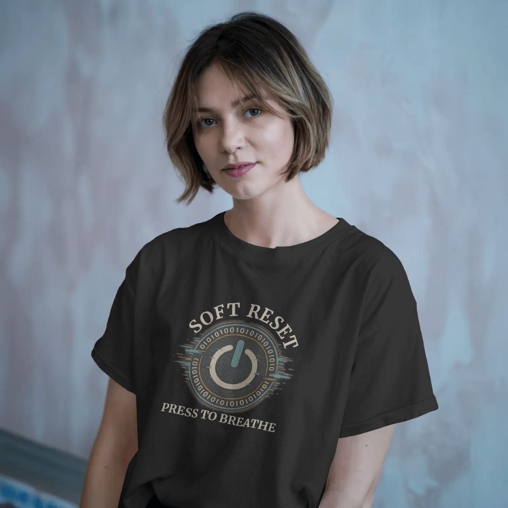 Woman wearing black “Soft Reset” T-shirt with power button and binary code design, calm blue background.