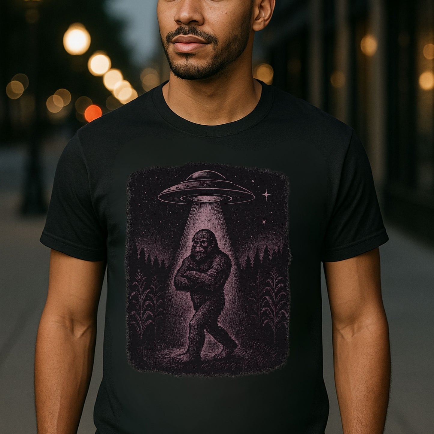 “Model wearing black Twistbug ‘UFO Abduction Sasquatch’ t-shirt on a night street—retro sci-fi graphic.