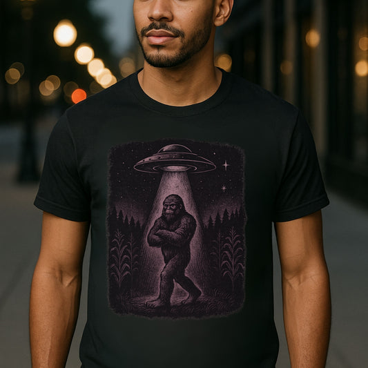 “Model wearing black Twistbug ‘UFO Abduction Sasquatch’ t-shirt on a night street—retro sci-fi graphic.