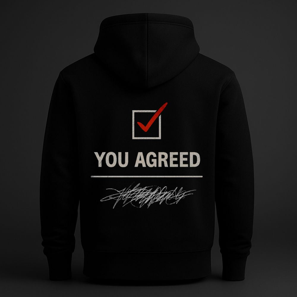 Black hoodie with “You Agreed” red checkmark back print in minimalist studio lighting

