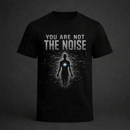 A black short-sleeve t-shirt with a graphic print on the front. The design features the text 'YOU ARE NOT THE NOISE' in a distressed white font above a dark silhouette of a person with a glowing blue chest light, set against a dark gray background.