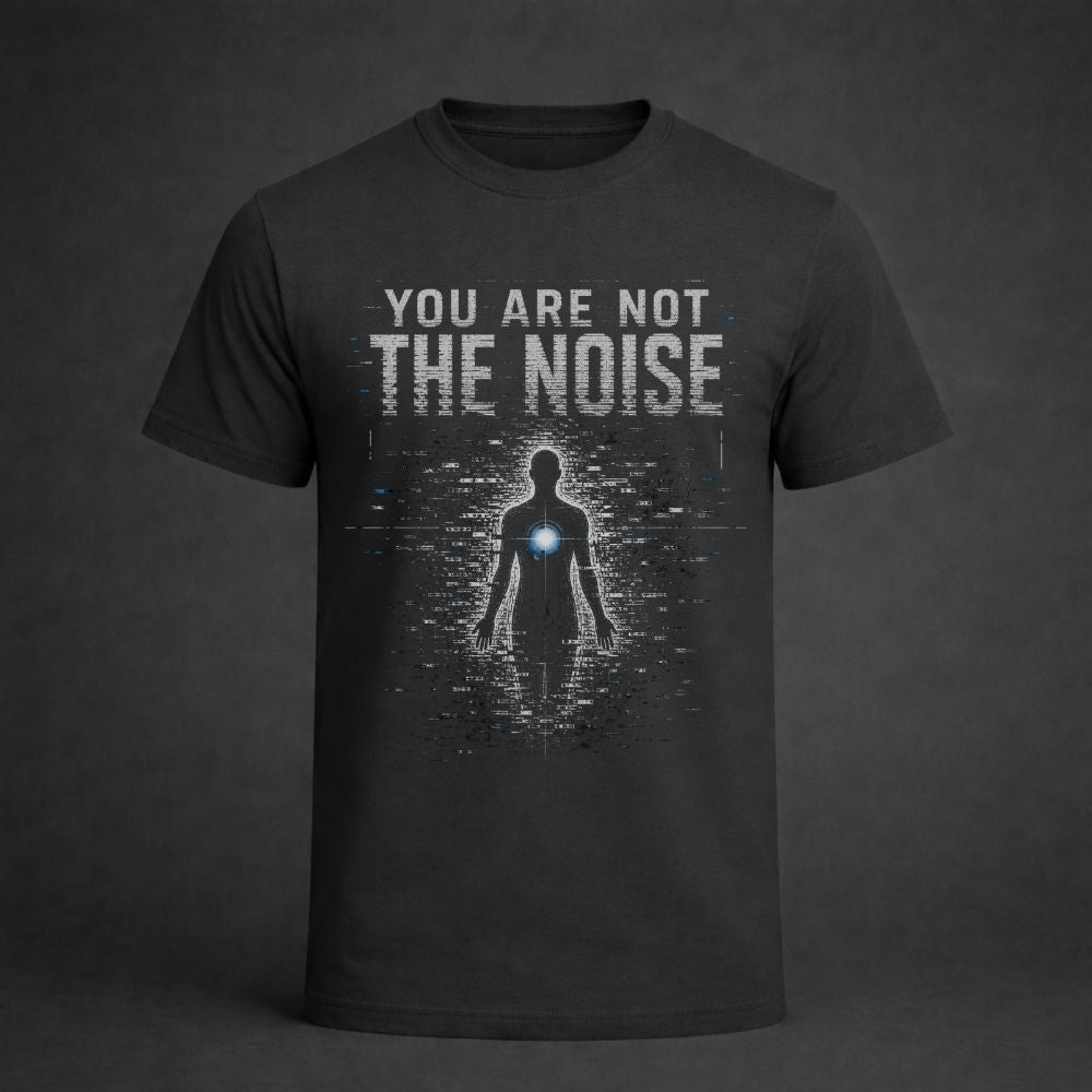 A dark charcoal gray t-shirt with a graphic print on the front. The print features the text 'YOU ARE NOT THE NOISE' in a distressed white font above a digital glitch effect of a human silhouette with a glowing blue chest light.