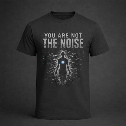 A dark charcoal gray t-shirt with a graphic print on the front. The print features the text 'YOU ARE NOT THE NOISE' in a distressed white font above a digital glitch effect of a human silhouette with a glowing blue chest light.
